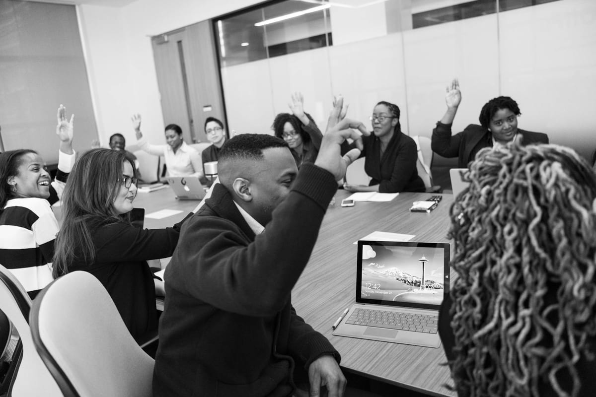 Residents raising hands to vote at an apartment owners' association general body meeting.