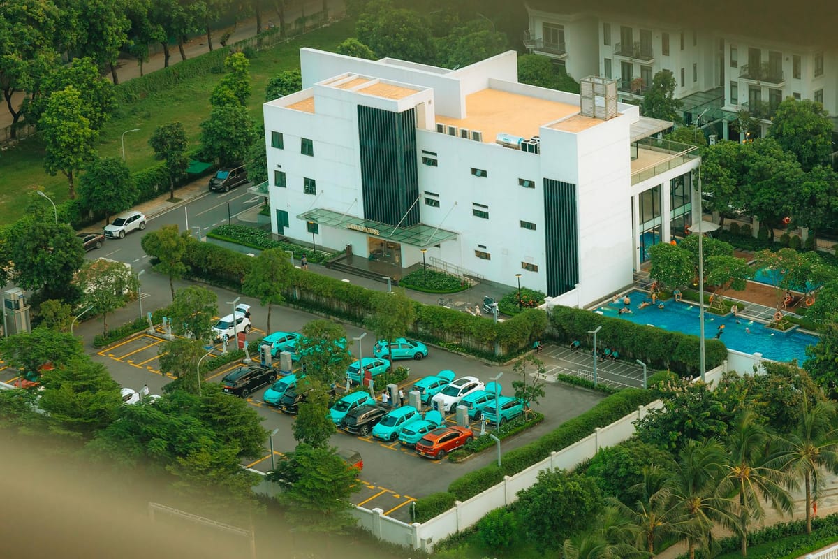 Aerial view of a residential apartment complex with a swimming pool and landscaped gardens, the kind of common areas a builder must hand over to the owners' association.