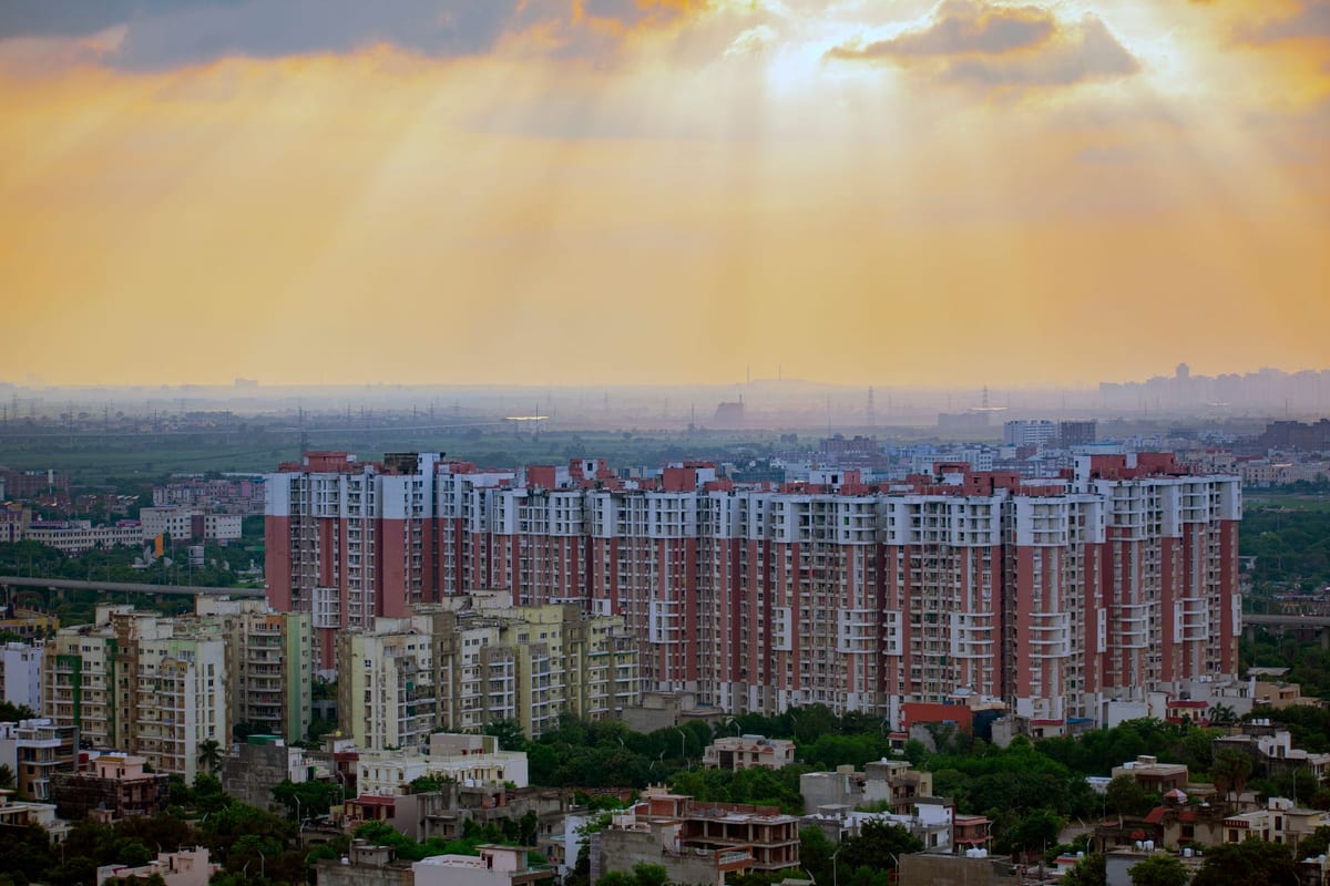 A skyline of high-rise residential towers across the Delhi National Capital Region, representing the multi-jurisdiction NCR property market