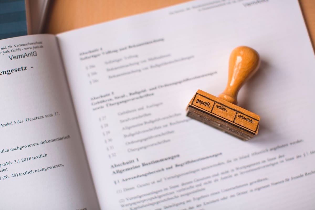 A wooden stamp resting on an open legal document, representing the sub-registrar value used to charge stamp duty at property registration